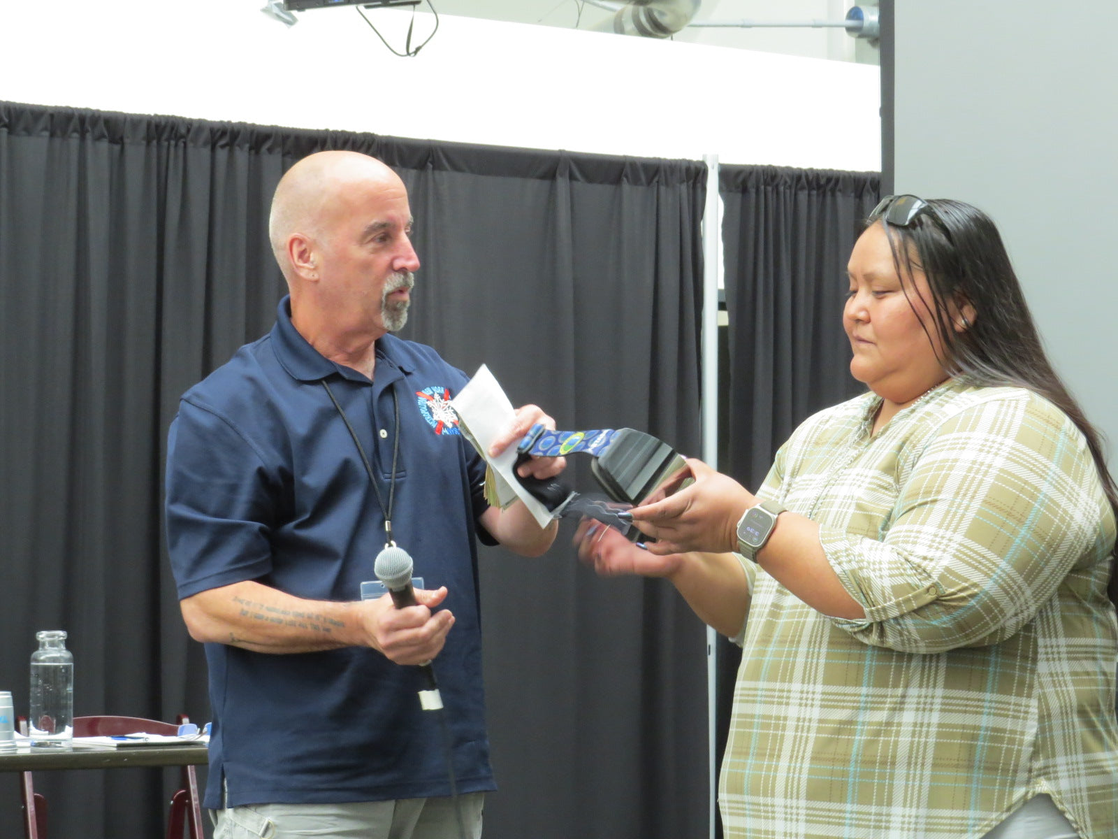 A woman holding a STAGE Custom Ski Goggle, the Frameless Prop with Mirror Chrome Smoke Lens.