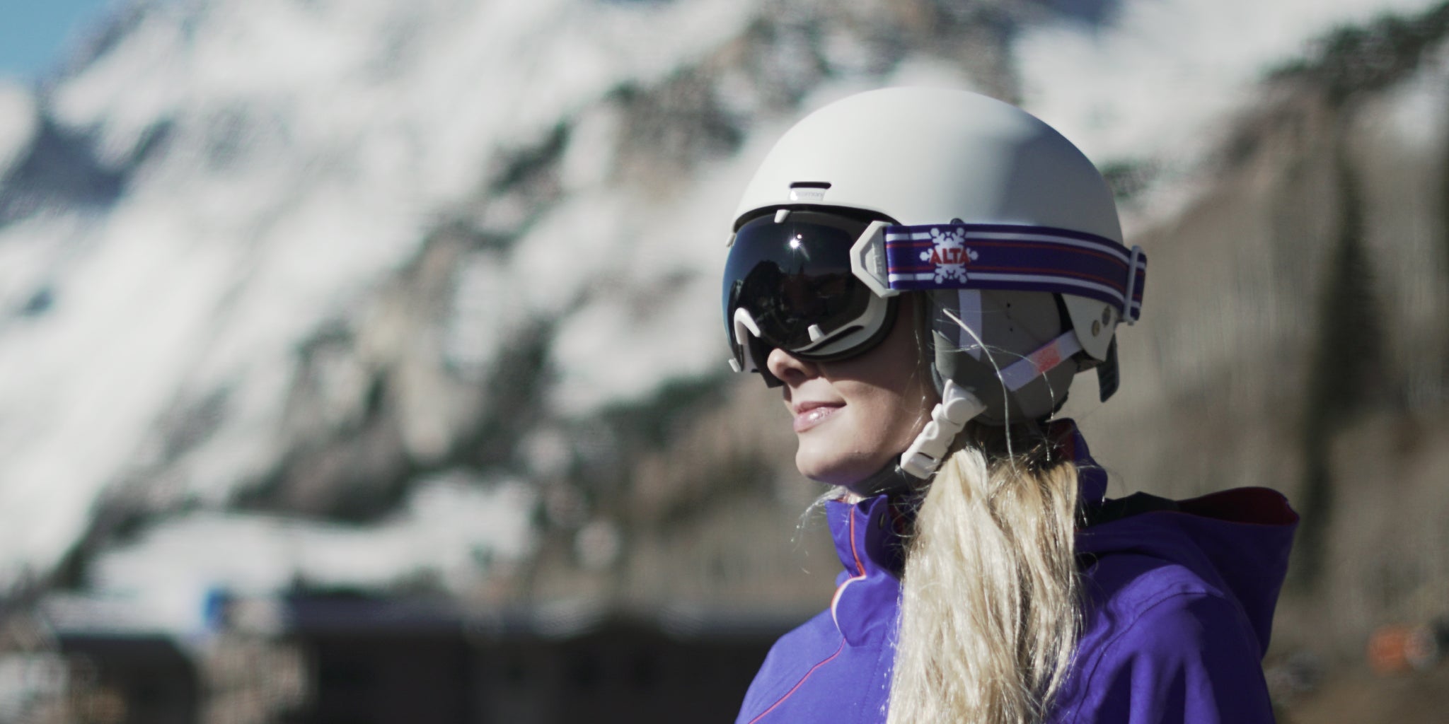 A woman wearing STAGE Custom Ski Goggles featuring ALTA Ski Resort's logo.