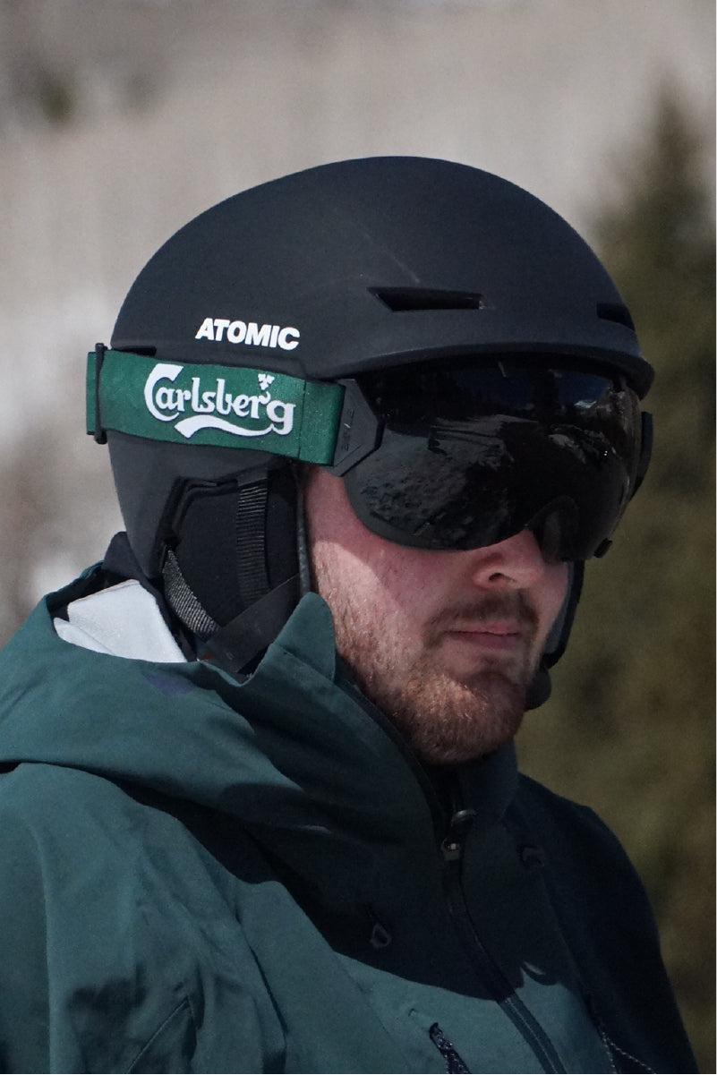 A man wearing STAGE Custom Ski Goggles featuring Carlsberg