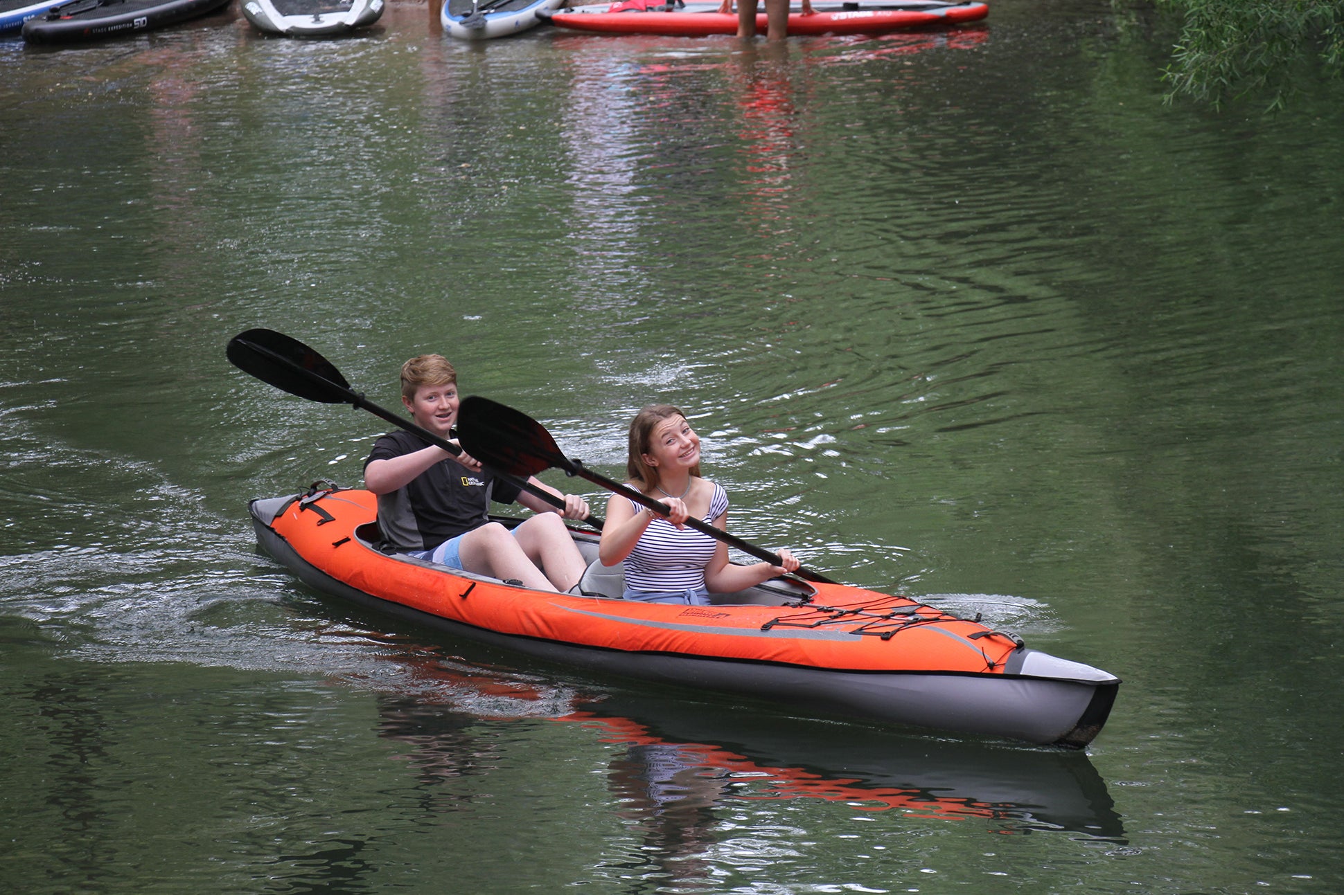 Two children kayaking with the STAGE 2-Piece Kayak Paddle and an Advanced Elements Inflatable Kayak